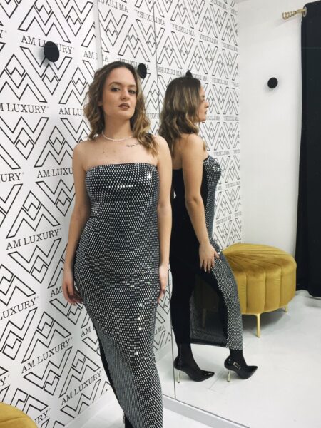 Abito con design lungo e fluido che valorizza la figura con un movimento elegante, mentre gli zirconi donano una luce straordinaria, rendendolo perfetto per ogni occasione.