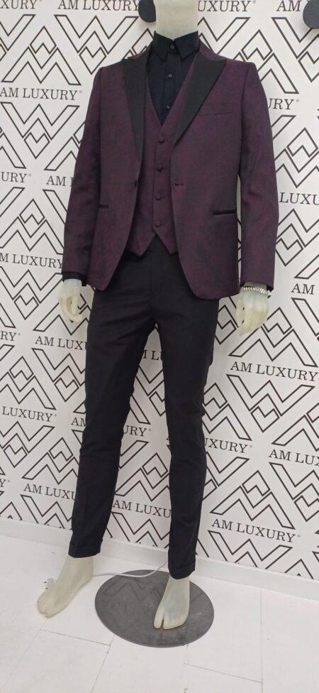 Vestito con giacca damascata, dona profondità e lusso al capo, mentre la tonalità bordeaux aggiunge eleganza senza tempo, mentre il pantalone si presenta semplice a gamba dritta.