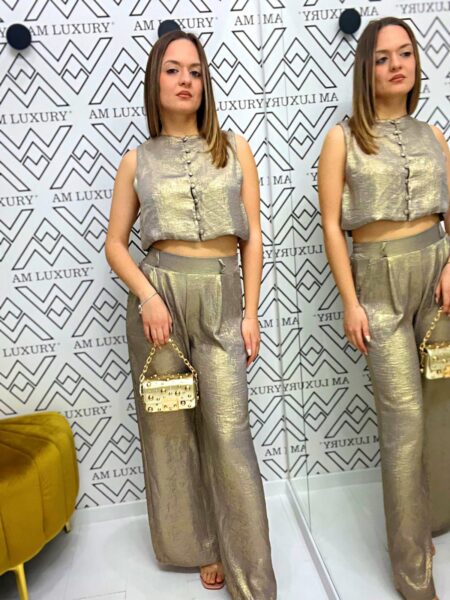 Coordinato in poliestere è caratterizzato da una giacca smanicata mentre il pantalone completa un set moderno.