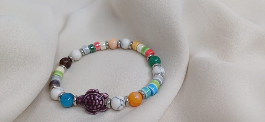 Bracciale artigianale in pietre colorate con elastico arricchito da charm - immagine 2