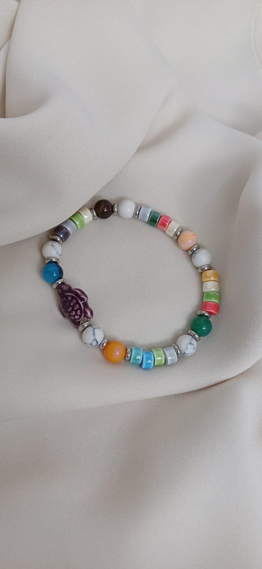 Bracciale artigianale in pietre colorate con elastico arricchito da charm