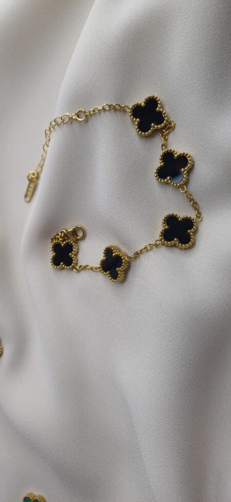 Bracciale color oro con ciodoli floreali nero lucido, chiusura regolabile