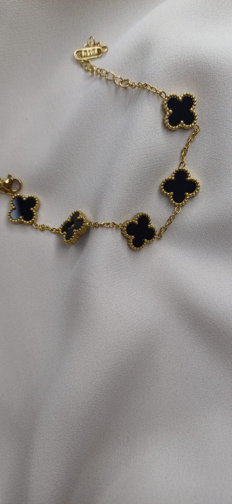 Bracciale color oro con ciodoli floreali nero lucido, chiusura regolabile - immagine 2