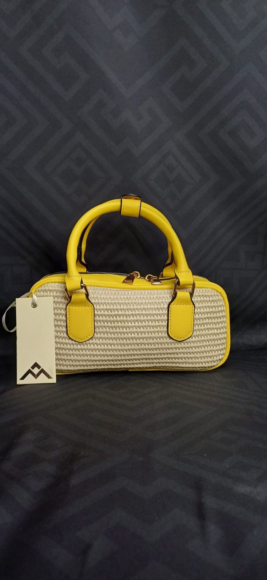 Borsa a mano e tracolla in paglia intrecciata con dettagli in ecopelle.