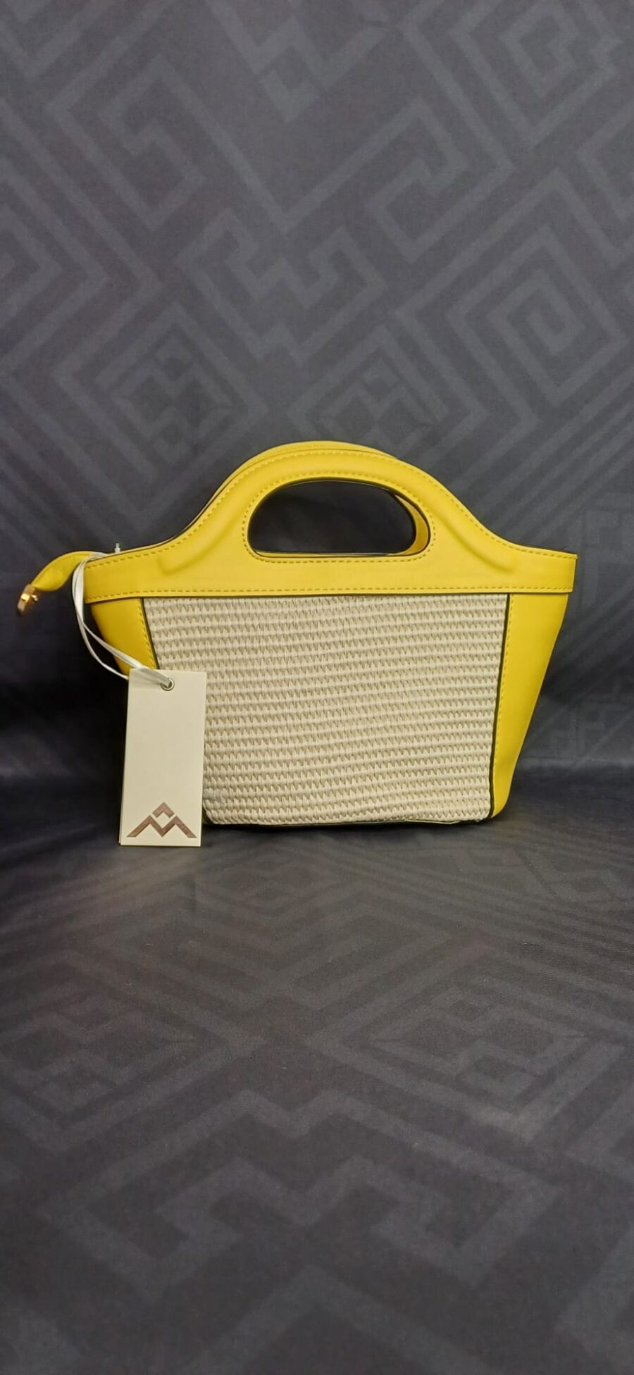 Borsa rigida a mano con tracolla in paglia intrecciata e dettagli in ecopelle.