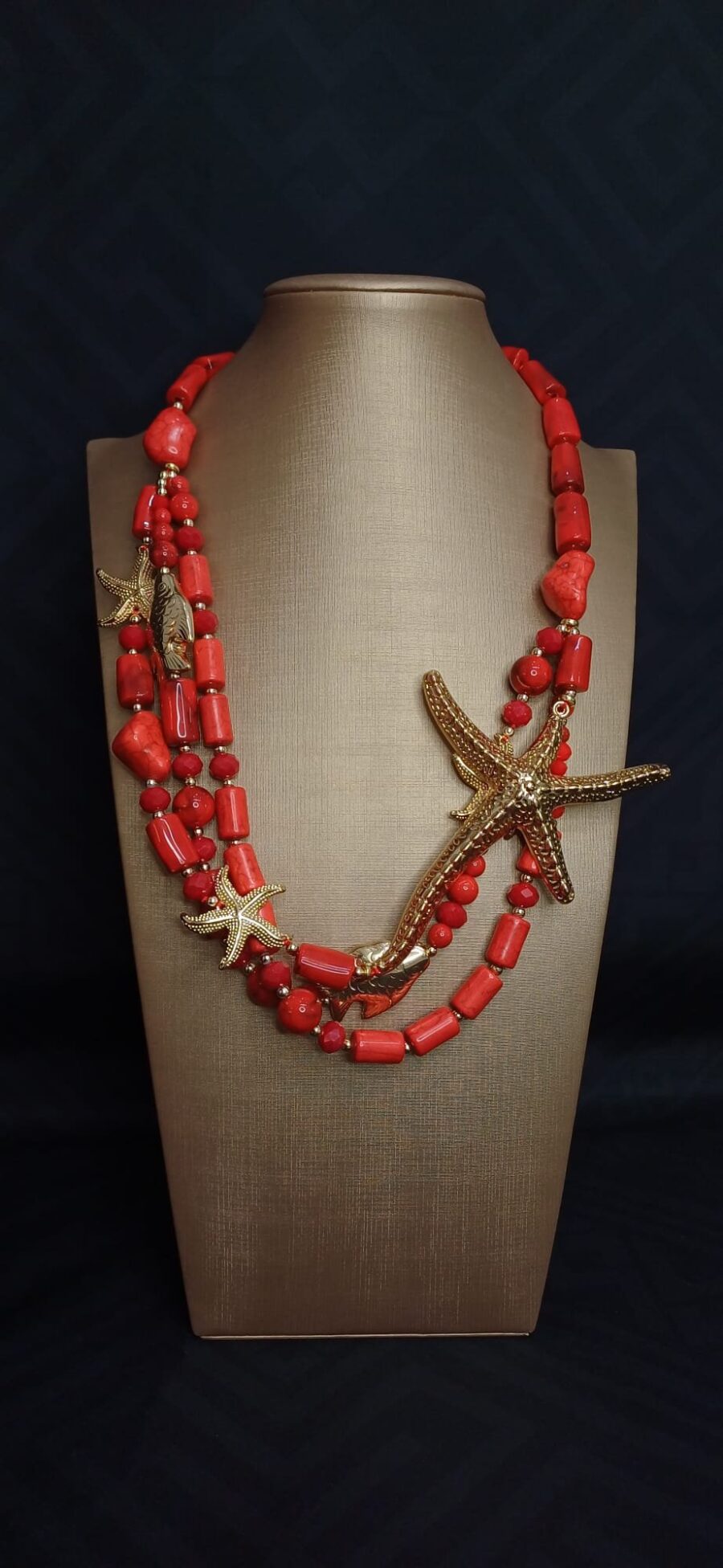 Collana corallo rosso con dettagli marini dorati.
