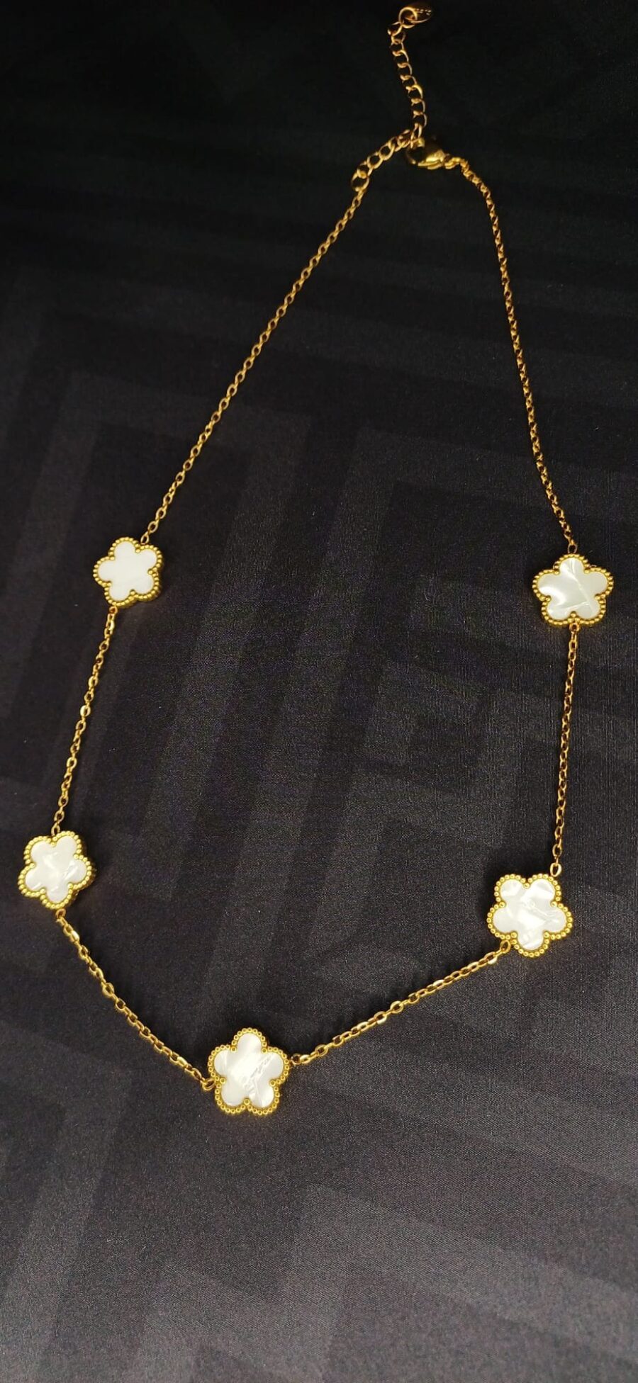 Collana color oro con ciondoli floreali bianco lucido, chiusura regolabile